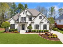 Stunning white brick home with a well-manicured lawn and mature trees offering curb appeal at 7430 Polo Hl, Cumming, GA 30040