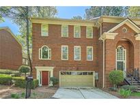 Charming brick townhome featuring an attached garage and a well-maintained front yard at 7155 Roswell Rd # 15, Atlanta, GA 30328