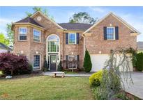 Charming brick home featuring manicured lawn, bench, and mature trees, with beautiful windows at 2898 Stockbridge Way, Dacula, GA 30019