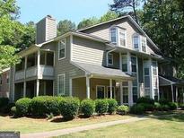 Charming multi-story home with a covered porch, trimmed bushes and lawn at 6390 Magnolia Ln, Morrow, GA 30260