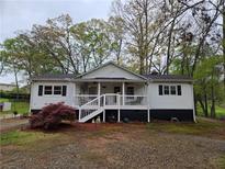 Charming single-story home with a welcoming front porch and meticulously kept landscaping at 4620 Oak Grove Cir, Cumming, GA 30028