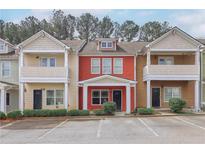 Charming townhouse featuring a red exterior, well-maintained landscaping, and convenient parking at 1797 Brookside Lay Cir, Norcross, GA 30093