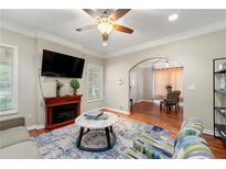Cozy living room featuring a fireplace, ceiling fan, and an open archway to the dining area at 1326 Mcpherson Ave., Atlanta, GA 30316