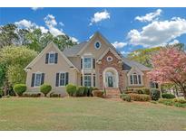 Stunning two-story home featuring a manicured front lawn and a combination of stone and stucco facade at 1405 Wilmington Way, Grayson, GA 30017