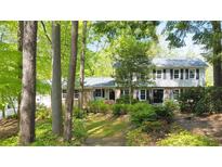 Charming two-story home with a well-manicured lawn and mature trees creating a serene, wooded setting at 2940 Blue Sky Pl, Marietta, GA 30068