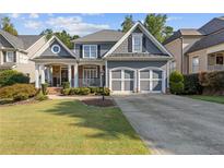 Charming two-story home featuring a well-manicured lawn, inviting porch, and a two-car garage at 5724 Kendrick Ln, Cumming, GA 30041