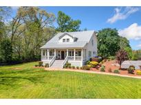 Charming two-story home with a metal roof and manicured lawn and landscaping at 4504 Union Hill Rd, Canton, GA 30115