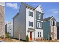Charming two-story home with a modern white and grey facade, an orange front door, and dark window shutters at 1332 Nw Creekside Cir, Atlanta, GA 30318