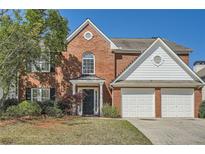 Charming brick home featuring a two-car garage and manicured landscaping at 3647 Bancroft Main Nw, Kennesaw, GA 30144