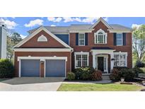 Charming brick two-story home featuring a two-car garage and well-manicured front yard landscaping at 3950 Almandine Way, Cumming, GA 30040