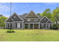 Stately two-story home featuring a combination of gray siding and brick, with a manicured lawn and mature trees at 1350 Blackwell Rd, Marietta, GA 30066