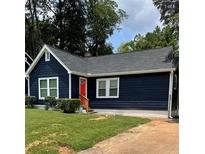 Charming home with a dark blue exterior, red door, and well-manicured lawn at 609 Spring St, Atlanta, GA 30354