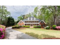 Stately brick home with a beautiful lawn, mature trees and large front porch at 1886 Chedworth Ct, Stone Mountain, GA 30087