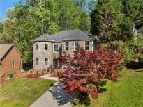 Charming two-story brick home with landscaped yard and mature trees, offering a welcoming curb appeal at 6960 Dockbridge Way, Stone Mountain, GA 30087