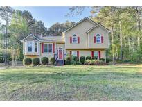 Charming two-story home with red shutters, complemented by mature trees and a well-manicured lawn at 6040 Carriage Dr, Cumming, GA 30028