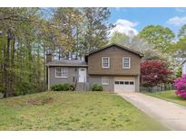 Charming split-level home with a well-maintained front yard and an attached one-car garage at 570 Bell Se Rd, Conyers, GA 30094