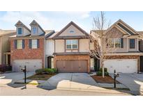 Charming townhome featuring a brick and siding exterior, attached garage, and well-maintained landscaping at 6625 Story Cir, Norcross, GA 30093
