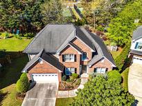 Stunning brick home featuring a two-car garage and lush landscaping, perfect for curb appeal at 1630 Chadwick Mill Ln, Lawrenceville, GA 30043