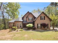 Beautiful two-story brick home featuring a manicured lawn and mature trees at 90 Belleview Rdg, Sharpsburg, GA 30277