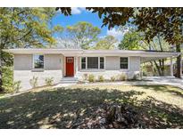 Charming single-story home with a white brick exterior and a vibrant red front door at 293 Howell Sw Dr, Atlanta, GA 30331