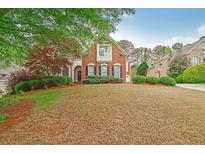 Charming brick home featuring well-manicured landscaping and classic architectural details at 3022 Woodbridge Ln, Canton, GA 30114
