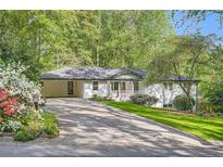 Charming white home with an attached covered parking area and a well-maintained landscaped front yard at 4020 Morgan Rd, Tucker, GA 30084