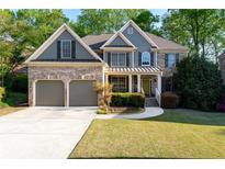 Charming two-story home with manicured lawn, brick accents, and a two-car garage at 1207 Promontory Path, Marietta, GA 30062