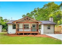 Charming home featuring a welcoming front porch and a well-maintained lawn at 2831 Ivanhoe Se Ln, Smyrna, GA 30082
