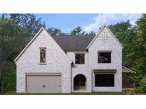 Striking two-story home with painted brick, arched entryway, two-car garage, and dormer windows at 380 Hillcrest View Dr, Suwanee, GA 30024