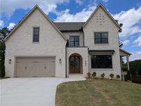 Elegant two-story home features a painted brick exterior and a well-manicured lawn at 380 Hillcrest View Dr, Suwanee, GA 30024