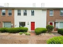 Charming townhouse featuring a red front door and well-manicured green shrubbery at 104 Holcomb Ferry Rd, Roswell, GA 30076