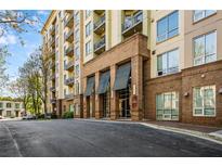 Stately brick apartment building with covered entrance, and multiple balconies on a tree lined street at 711 Cosmopolitan Ne Dr # 213, Atlanta, GA 30324