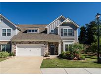 Charming two-story home with stone accents, neutral siding, and a well-maintained lawn, complemented by a two-car garage at 1809 Park Land Ln, Snellville, GA 30078