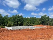 New home foundation on a construction site with lush green trees in the background on a bright sunny day at 3063 Reserve Sw Ct, Conyers, GA 30094