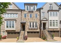 Charming townhome with stone facade, brown garage door, and stairs leading to front door at 705 Abbington River Ln, Atlanta, GA 30339