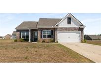 Charming brick home featuring stone accents, a two-car garage, and a well-manicured lawn at 1259 Fendt Dr, Locust Grove, GA 30248
