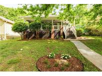 Charming home featuring a inviting front porch, landscaped yard, and stone walkway at 1412 Woodbine Se Ave, Atlanta, GA 30317