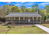 Charming single-story home with a welcoming front porch and landscaped yard at 507 Honeysuckle Ln, Woodstock, GA 30188