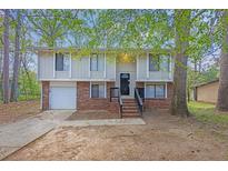 Two-story home featuring brick accents, light-colored siding, a dark front door, and a well-manicured front yard at 616 Country Lane Dr, Jonesboro, GA 30238