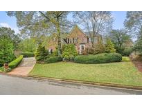 Charming brick home featuring a well-manicured lawn and mature landscaping, perfect for curb appeal at 2370 Steeplechase Ln, Roswell, GA 30076