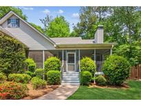 Charming home with a screened-in porch and well-maintained landscaping at 7675 Rose Ln, Cumming, GA 30040