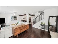 Open-concept living room with hardwood floors, a ceiling fan, white sofa, and seamless access to the dining area at 1152 Hampton Ne Way, Atlanta, GA 30324