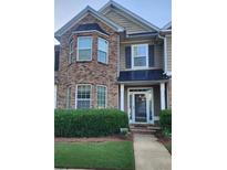 Charming two-story townhouse with brick facade and manicured landscaping at 5449 Festival Ave, Fairburn, GA 30213