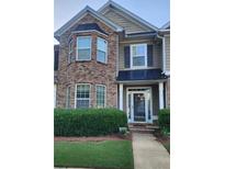 Charming townhome with brick facade, covered porch, and manicured landscaping at 5449 Festival Ave, Fairburn, GA 30213
