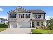 Charming two-story home featuring a two-car garage, a stone and brick facade, and a beautifully landscaped front yard at 1139 Blue Juniper Cir, Loganville, GA 30052