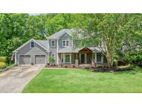 Charming two-story home with a manicured lawn, a welcoming porch, and an attached two-car garage at 1514 Maplewood Ct, Woodstock, GA 30189