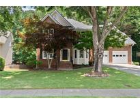 Charming two-story brick home featuring an attached two-car garage and a beautifully landscaped front yard at 3335 Maple Terrace Dr, Suwanee, GA 30024