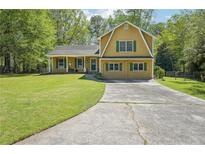 Charming two-story home with yellow siding, green shutters, and a well-manicured front lawn at 1522 Sprayberry Dr, Marietta, GA 30066