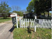 A cozy home with a white picket fence and a 'For Sale' sign in the front yard at 1895 Thomasville Se Dr, Atlanta, GA 30315