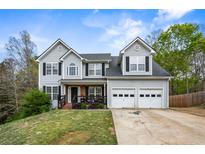 Charming two-story home with attached two-car garage, dark shutters, and a landscaped front yard at 2077 Alcovy Trace Way, Lawrenceville, GA 30045